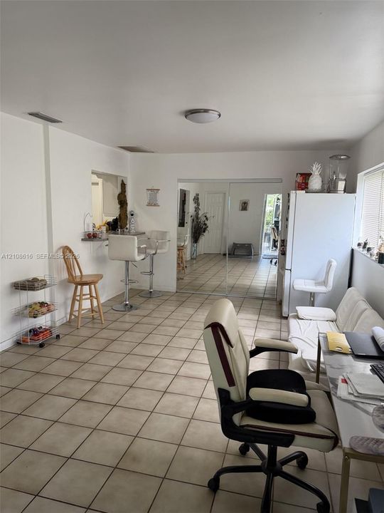 Ceramic tile flooring, mirrored closet doors, and a built-in pass-through window with an integrated counter