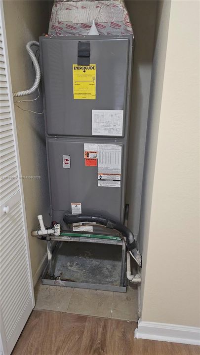 High-efficiency HVAC furnace unit featuring a gray metal housing and rigid pipe connections