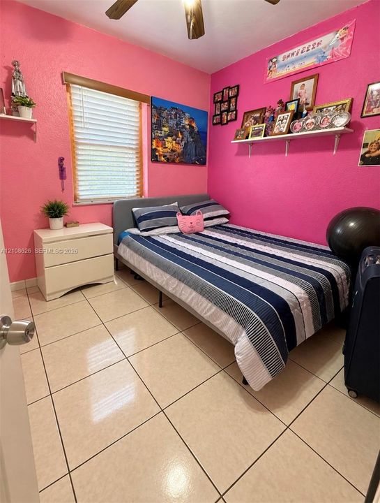 Ceramic tile flooring, horizontal slat window blinds, ceiling fan, and wall-mounted shelving