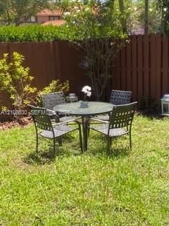 Private backyard featuring a fenced perimeter, grass lawn, and mature landscaping