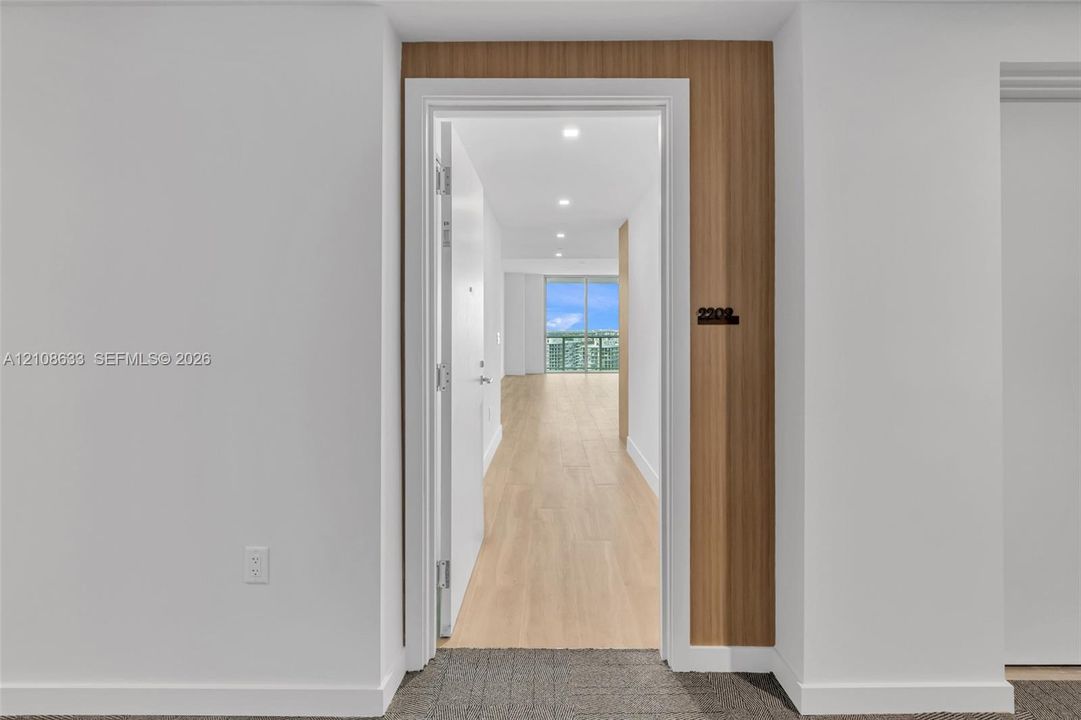 Entryway featuring wood-finish paneling, white interior door, recessed lighting, and wood-finish flooring