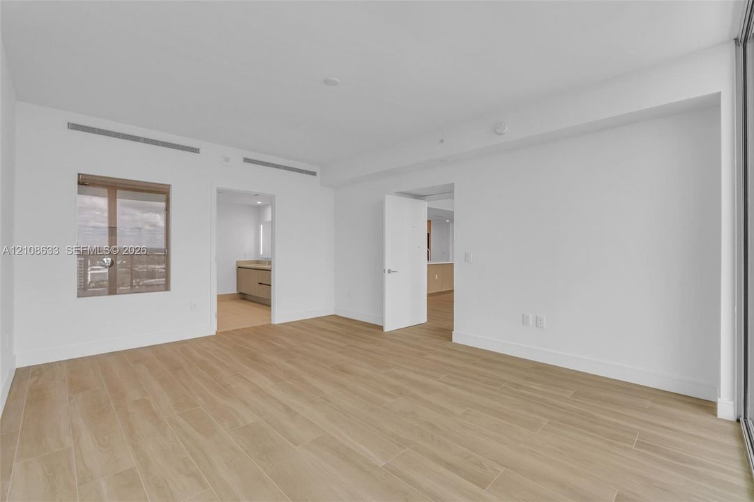 Interior space featuring wood-finish flooring, white walls, and a large window