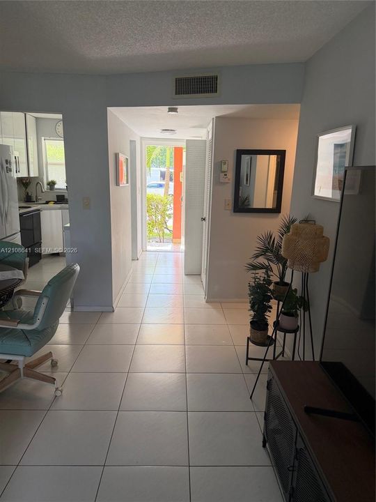 Neutral-toned ceramic tile flooring, clean architectural lines, and direct access to an exterior entrance