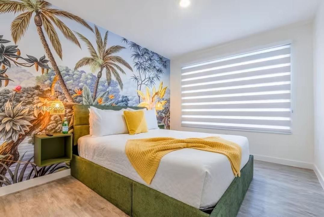 Wall-to-wall mural featuring a botanical palm tree motif, wood-finish flooring, and recessed ceiling lighting