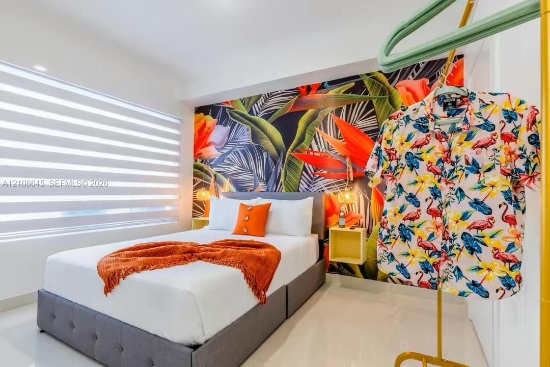 Interior space featuring large-scale botanical wall treatment, recessed ceiling lighting, and horizontal tiered window shades