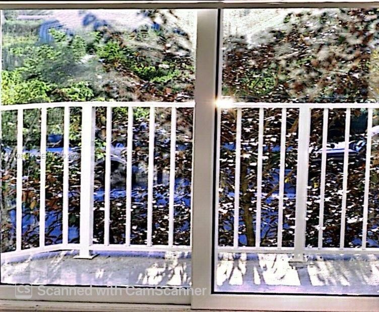 Balcony featuring white metal railings and sliding glass doors