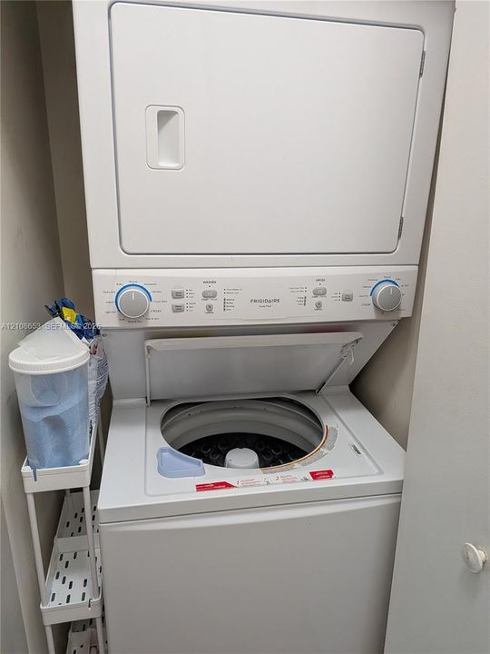 Stacked Frigidaire laundry unit featuring a white top-loading washer and integrated dryer