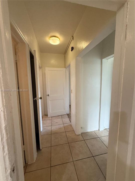 Ceramic tile flooring, multiple interior solid-core doors, and flush-mount ceiling lighting