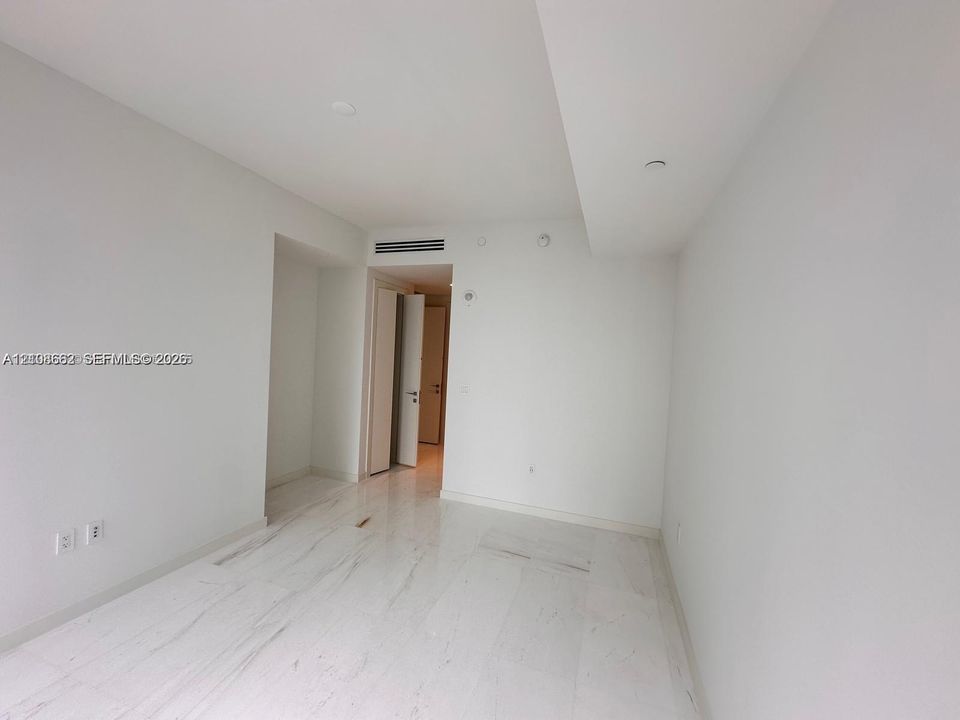 Open interior space featuring polished stone flooring, smooth high ceilings, and recessed lighting