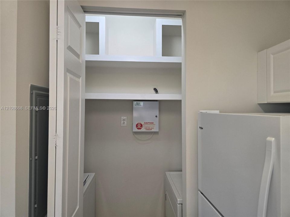 Built-in shelving units and interior closet space featuring solid-core door and neutral finish