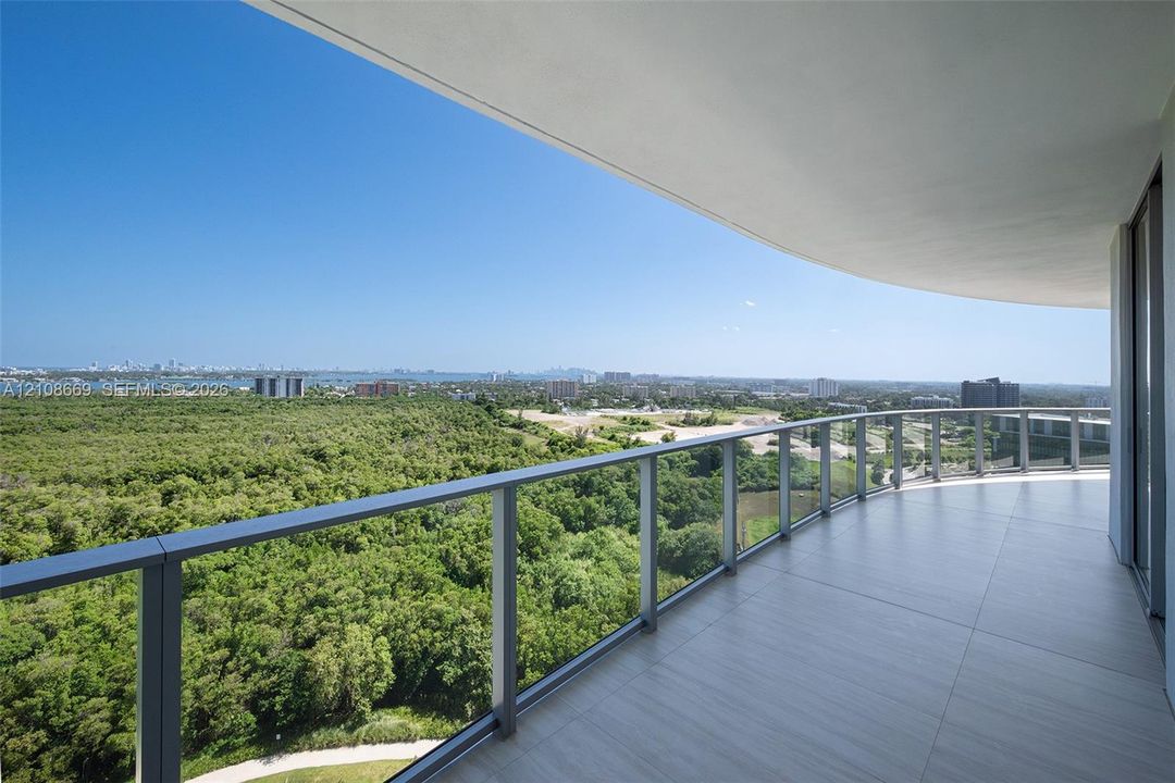 Covered balcony with large-format tile flooring and a glass panel railing