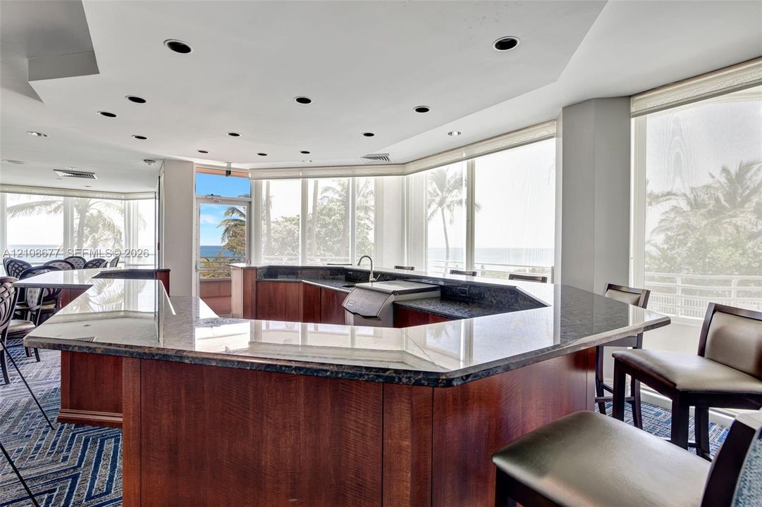 Wrap-around bar area in community room w/ floor-to-ceiling windows