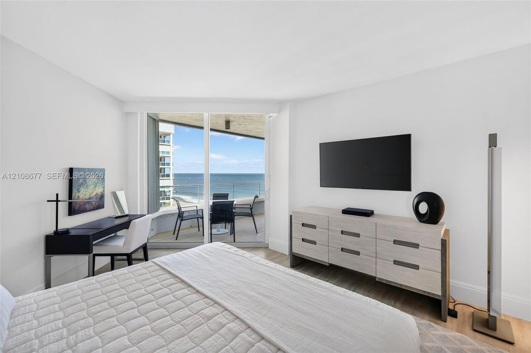 Full-height sliding glass doors opening to a private balcony, wood look plank porcelain  flooring, and expansive ocean views. Double layered (light filtering and room darkening) remote operated window shades by Bandalux