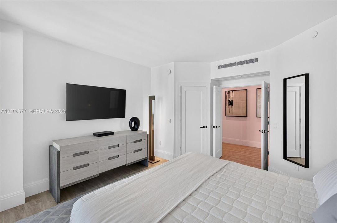 Bright interior space featuring neutral walls, wood look plank porcelain flooring, double-panel interior doors