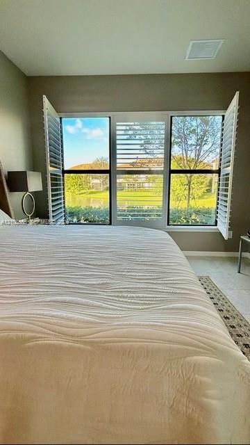 Large multi-pane window with white plantation shutters and water scenery