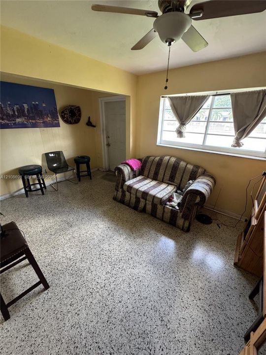 Terrazzo flooring, multi-pane window, and ceiling fan with integrated lighting