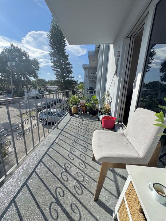Covered balcony featuring concrete flooring and decorative metal railings