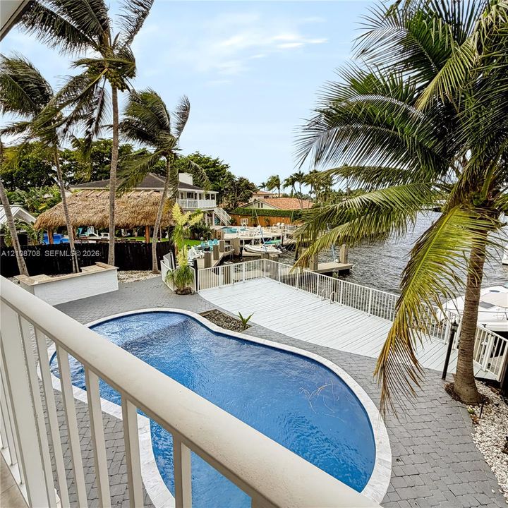Waterfront backyard with pool, tiki hut and private dock