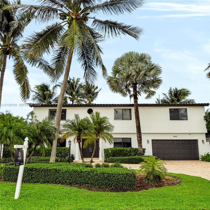 Front entrance with palms and manicured landscaping