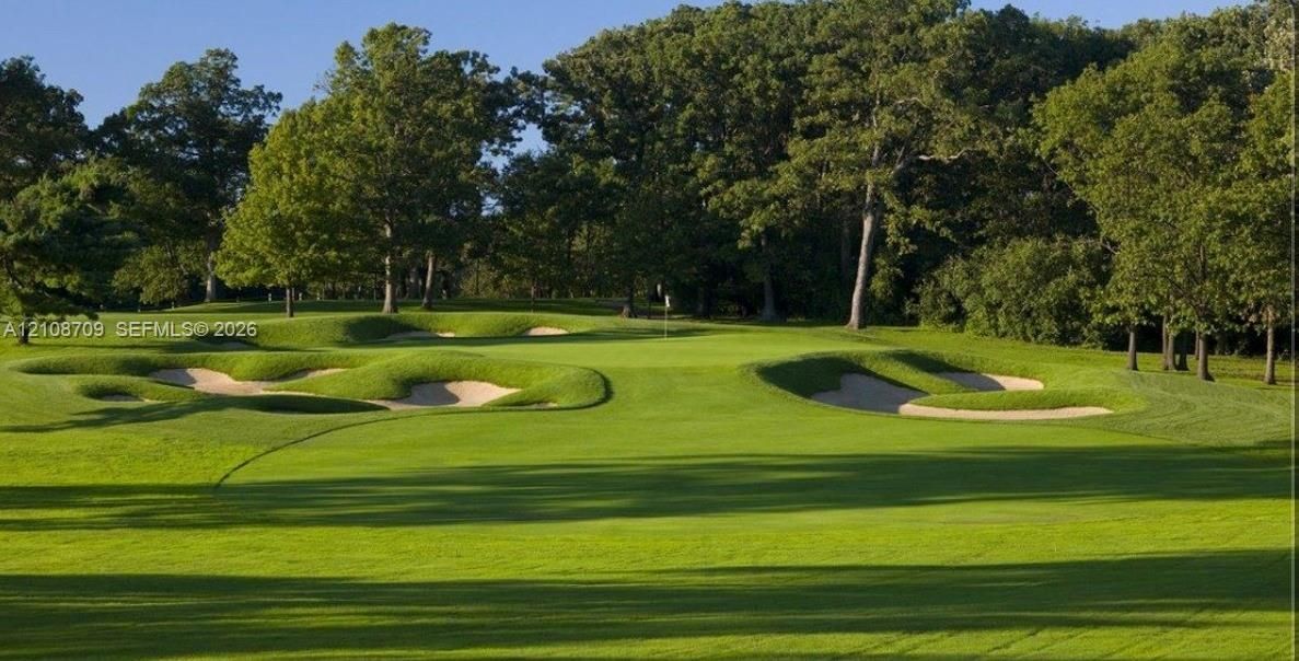 Expansive golf course grounds featuring manicured fairways, sand bunkers, and mature perimeter trees