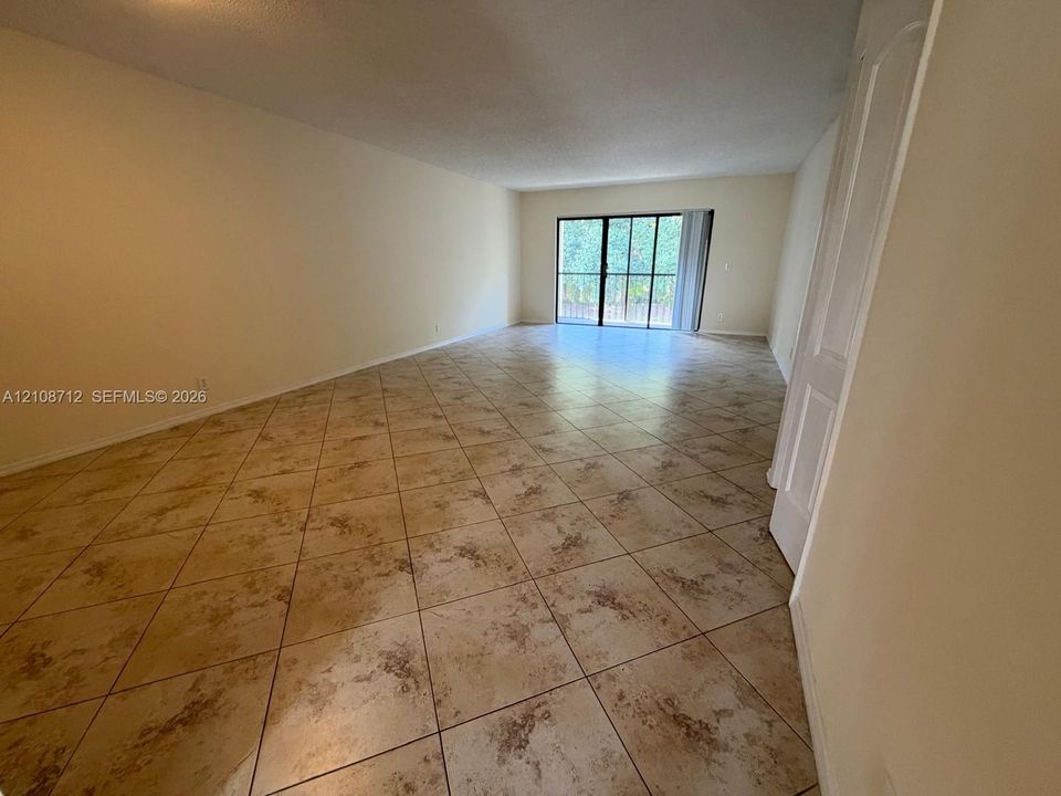 Interior space featuring diagonal-set tile flooring and a sliding glass door with a black frame