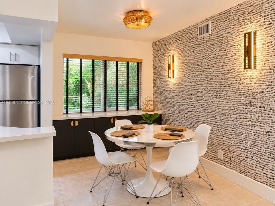 Dining area featuring a statement textured accent wall, built-in cabinetry with metallic hardware, dual wall-mounted light fixtures, and a flush-mount overhead light