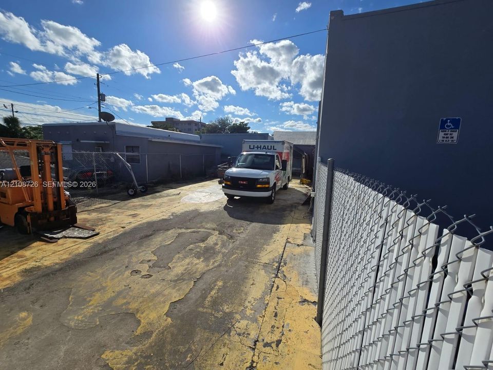 Exterior paved area featuring perimeter chain-link fencing and concrete masonry unit structures