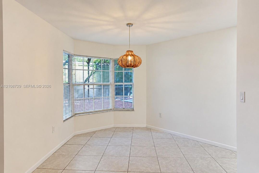 Breakfast nook featuring a bay window, ceramic tile flooring, and a pendant light fixture