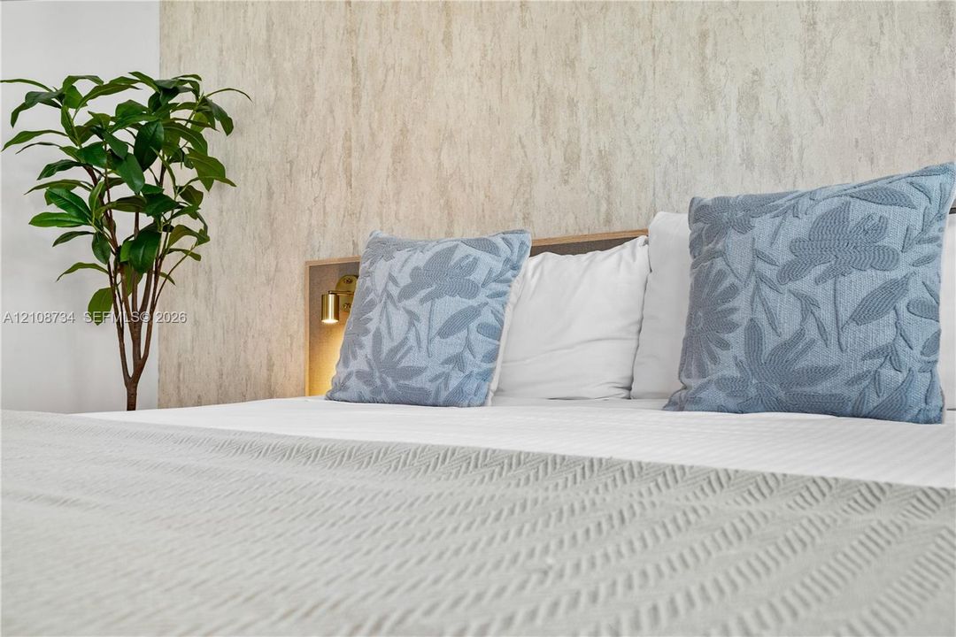 Textured stone-finish accent wall with integrated warm-toned wall-mounted lighting