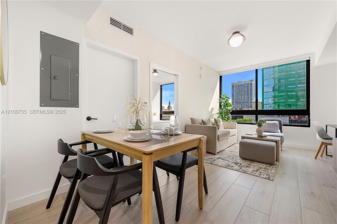 Floor-to-ceiling windows featuring urban scenery, wood-finish flooring, and recessed ceiling lighting