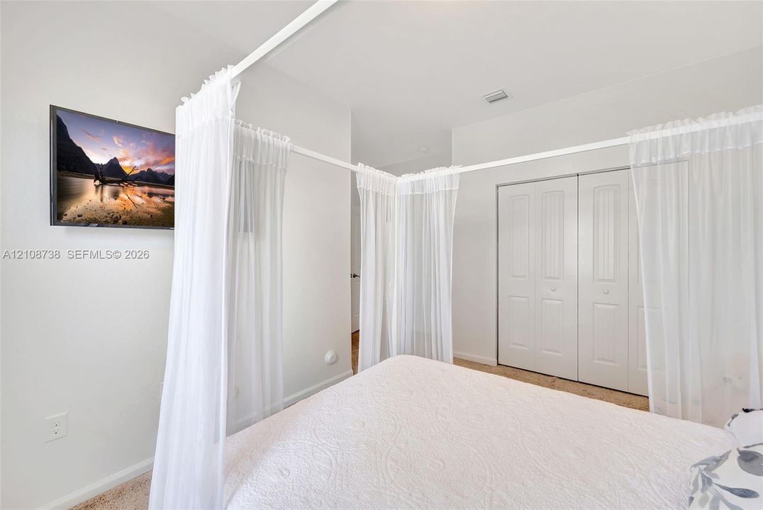 Neutral wall-to-wall carpeting, white interior paint, and sliding double-panel closet doors