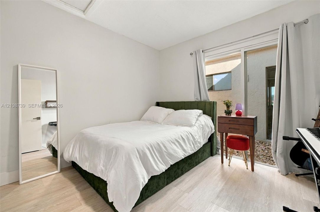 Interior space featuring neutral wall paint, wood-finish flooring, and a large sliding glass door