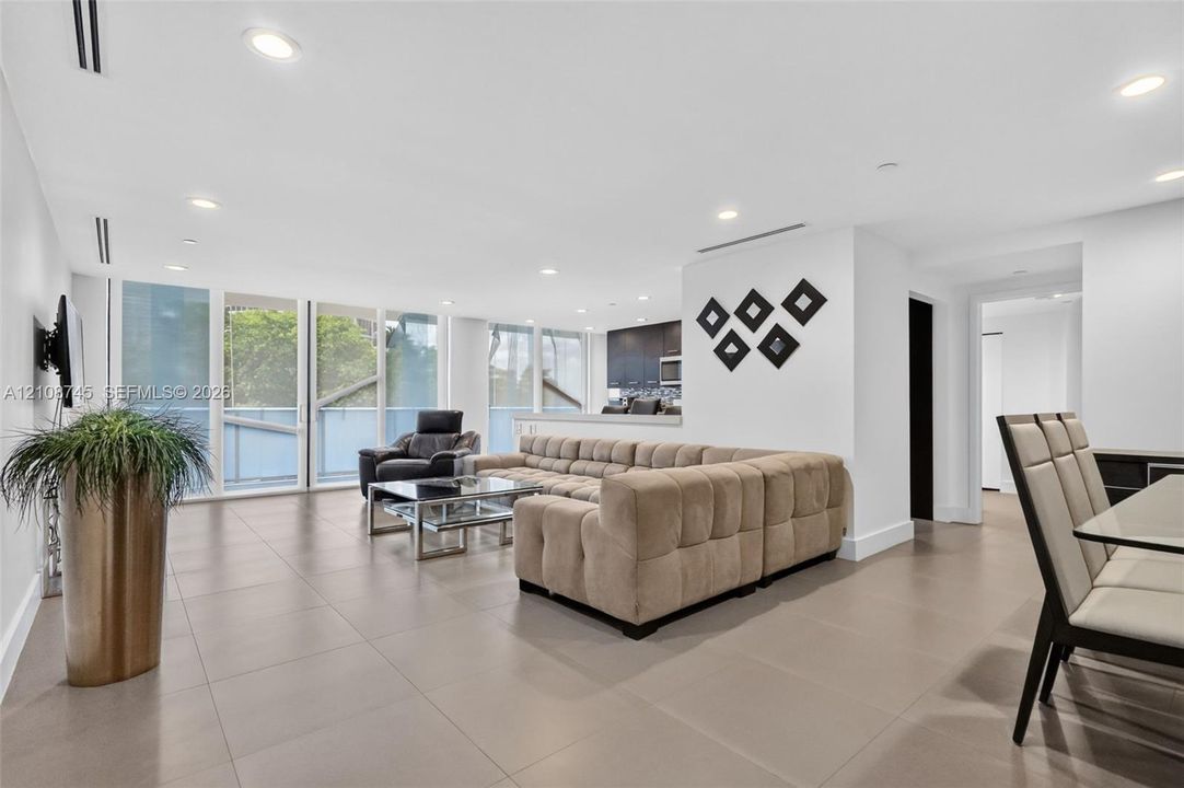 Open-concept interior featuring large-format tile flooring, recessed lighting, floor-to-ceiling windows, and linear ceiling vents