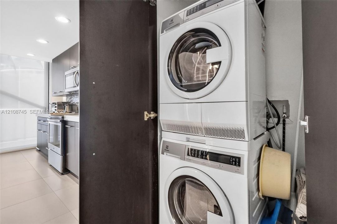 Stacked front-loading washer and dryer unit housed within a dedicated closet