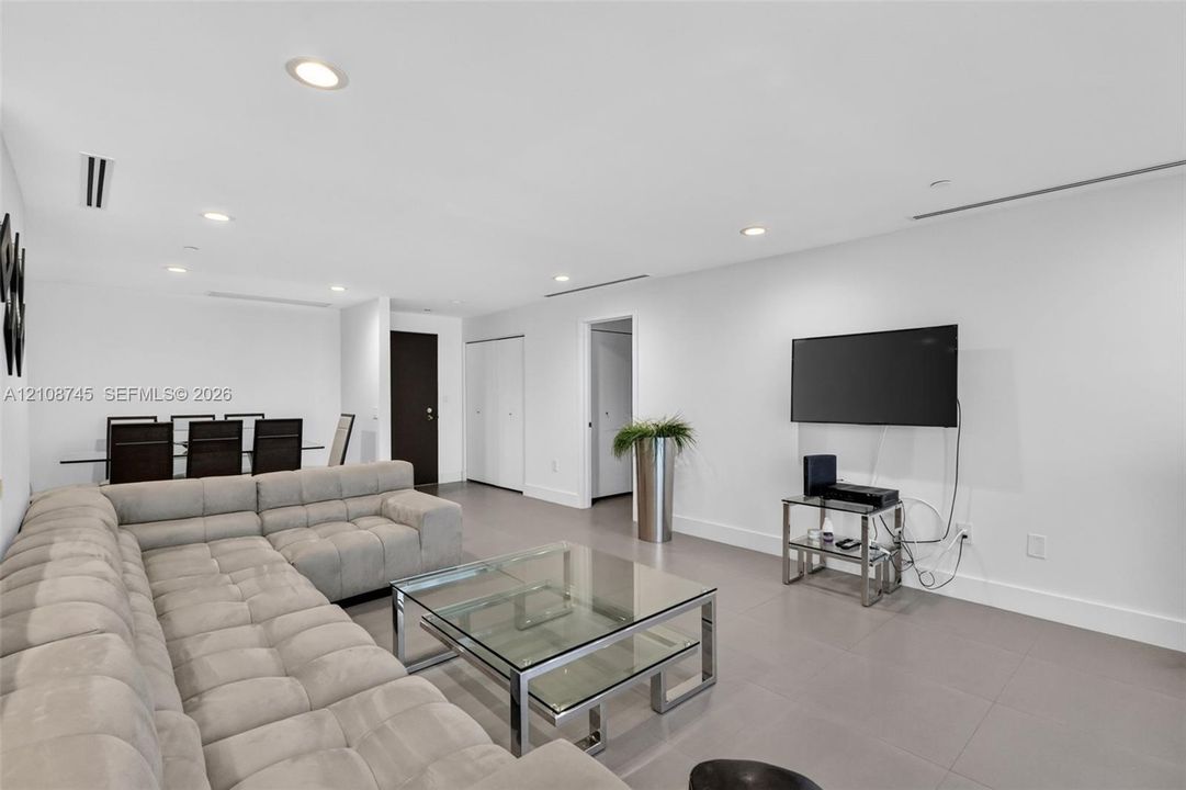 Open-concept interior featuring large-format tile flooring, recessed ceiling lighting, and linear HVAC diffusers