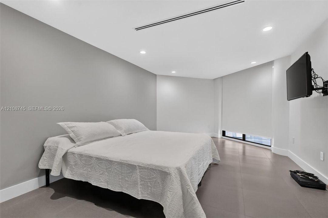 Room featuring large-format tile flooring, recessed lighting, and a linear HVAC diffuser