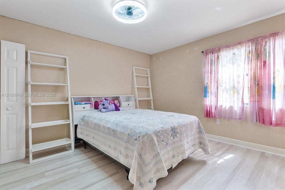 Room featuring wood-finish flooring, a flush-mount LED ceiling fan light, and an interior hinged closet door