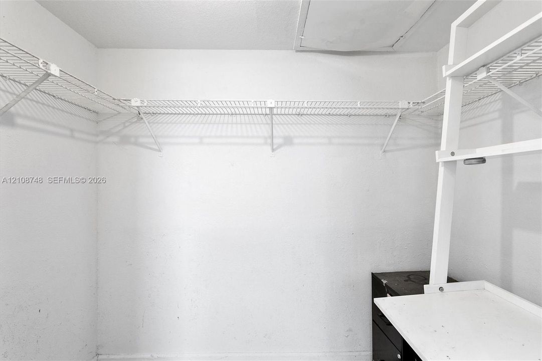 Storage area featuring white wire shelving and a built-in white tiered shelving unit
