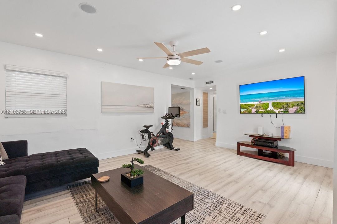 Room featuring wood-finish flooring, recessed lighting, and a multi-blade ceiling fan
