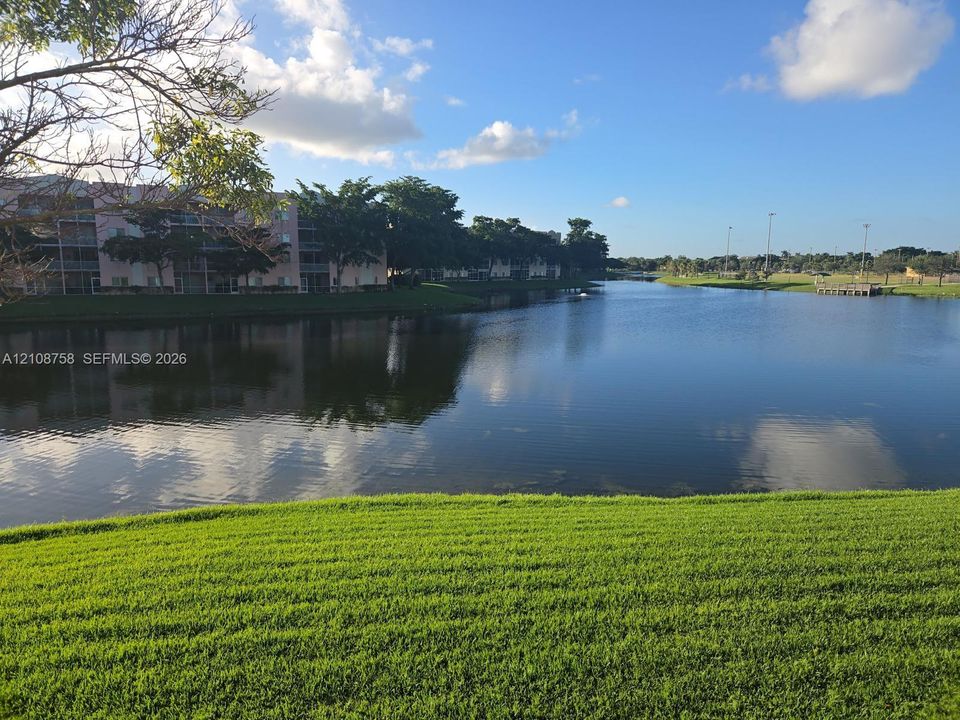 Waterfront parcel featuring a manicured grass lawn, mature trees, and an open expanse of water