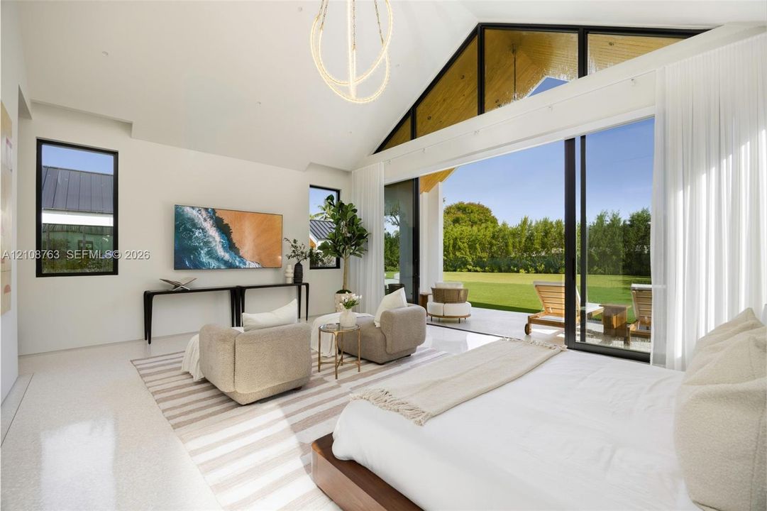 Vaulted ceilings with exposed timber detailing, expansive glass sliding walls, sleek polished flooring, and contemporary overhead lighting fixture