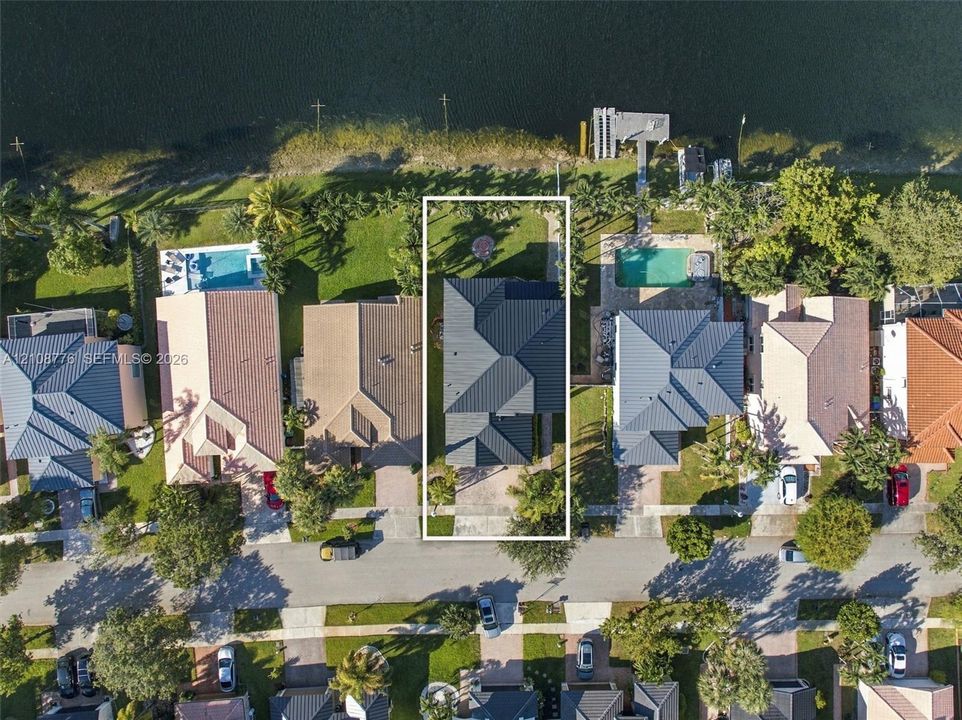 Waterfront property featuring direct canal access, a private dock, and a multi-pitched roof