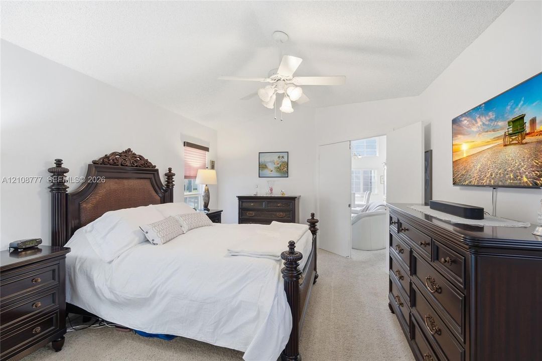Vaulted ceiling featuring a central white lighted ceiling fan