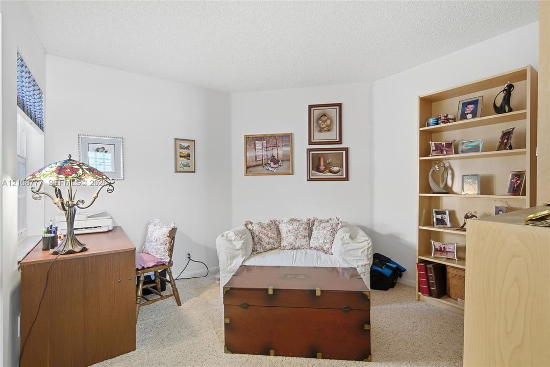 Room interior featuring neutral wall paint, carpeted flooring, and built-in wood shelving