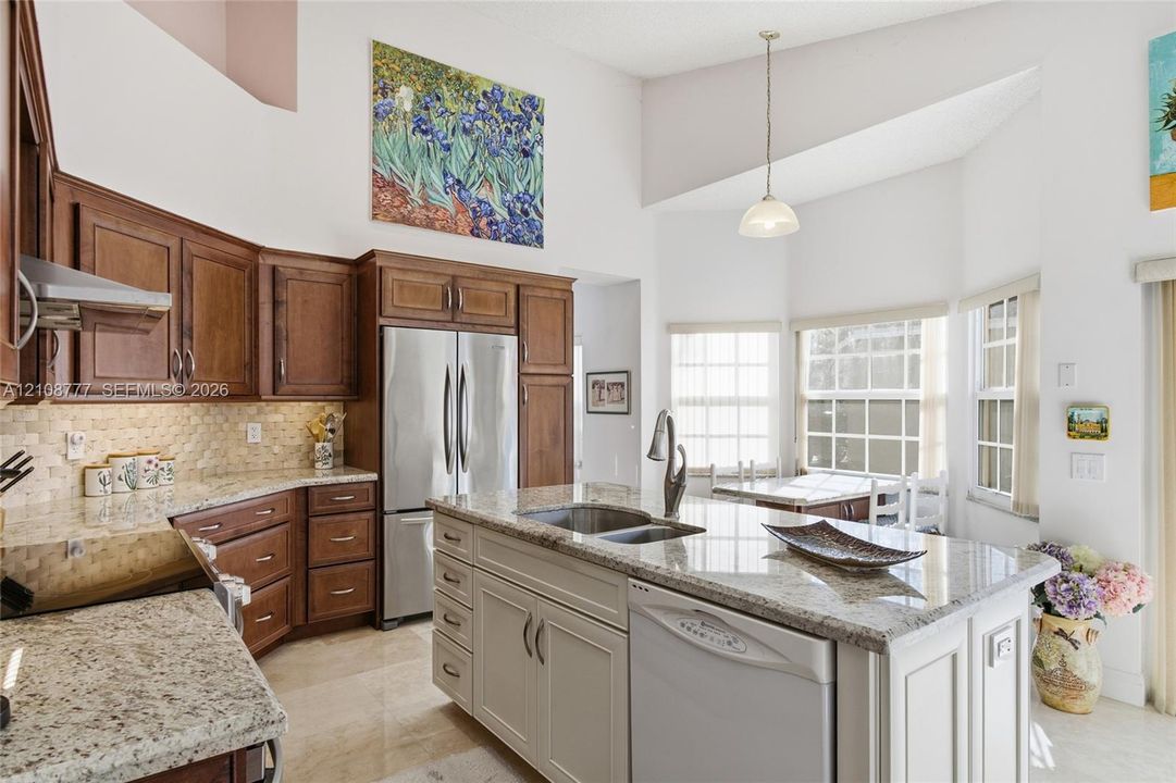 Kitchen featuring dark wood cabinetry, a central island with a stone countertop, stainless steel appliances, a tile backsplash, and a vaulted ceiling