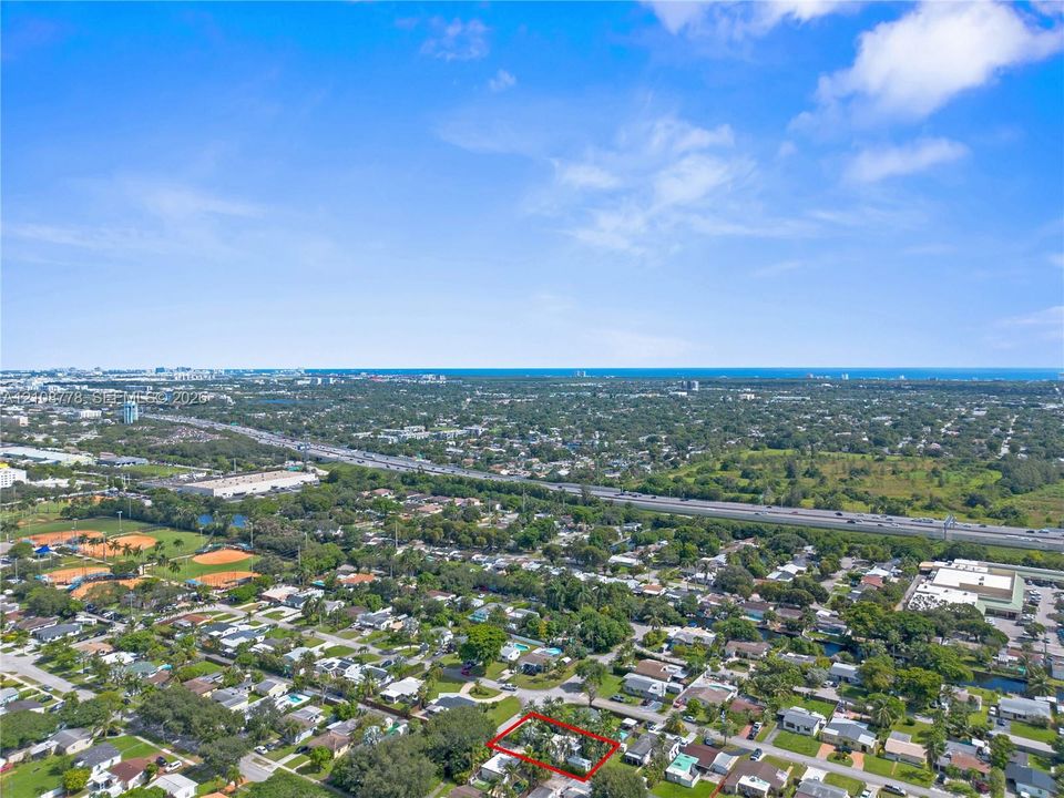 Aerial perspective of property featuring a marked boundary line, encompassing dense mature tree canopy and vegetation