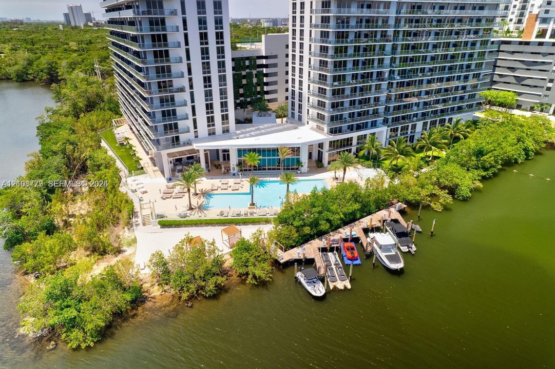 Waterfront high-rise property featuring a swimming pool, sundeck, and private boat slips along a canal
