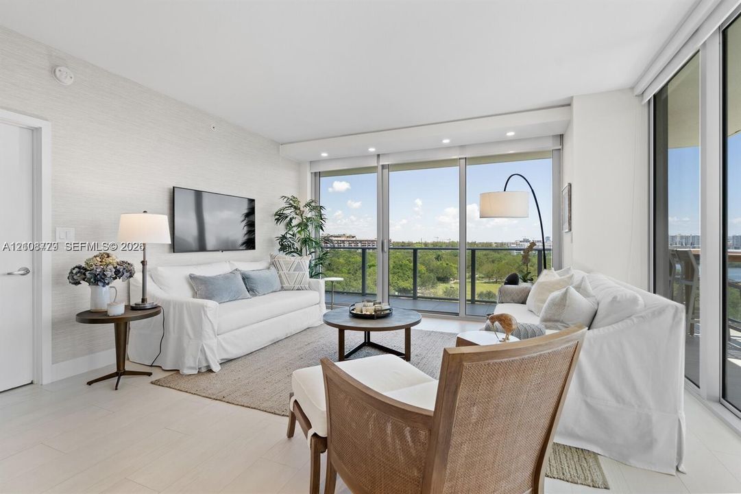 Living area featuring floor-to-ceiling glass sliding doors, recessed lighting, textured wall finishes, and light-toned tile flooring
