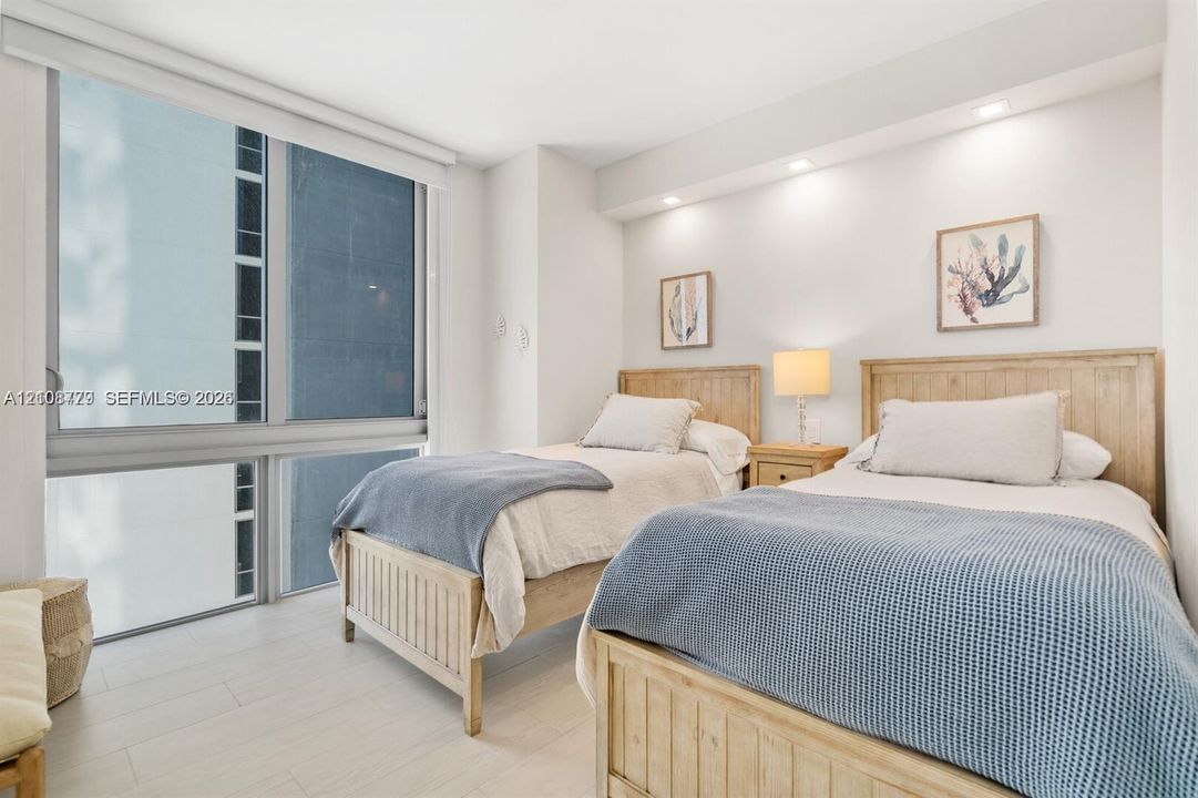 Floor-to-ceiling windows, wood-finish flooring, and recessed ceiling lighting