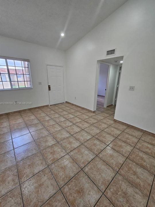 Vaulted ceiling, ceramic tile flooring, and multi-pane window